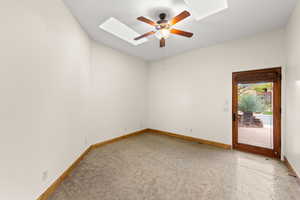 Empty room with a skylight and a ceiling fan