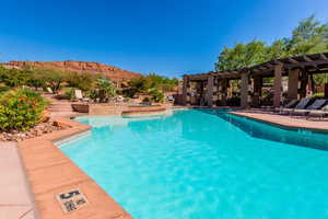 View of swimming pool featuring a pergola, a patio area, a mountain view, and a pool with connected hot tub