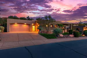 Pueblo-style house with stucco siding, driveway, and an attached garage