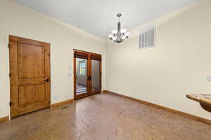 Empty room with baseboards and a chandelier