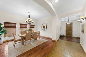 Dining room featuring a chandelier, wood-type flooring, and arched walkways