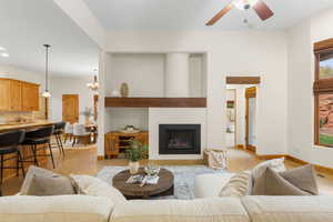 Living area with hanging lights, ceiling fan, and a large fireplace