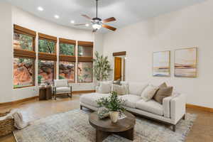 Living area with a high ceiling, a ceiling fan, and recessed lighting