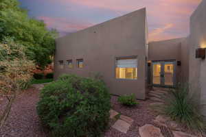View of home's exterior with stucco siding and french doors