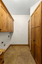 Laundry area featuring hookup for a washing machine, cabinet space, and hookup for an electric dryer