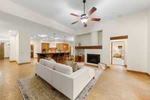 Living area featuring a large fireplace, a ceiling fan, and recessed lighting