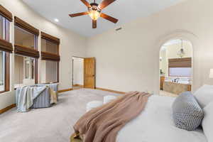 Bedroom featuring arched walkways, carpet flooring, a ceiling fan, ensuite bath, and recessed lighting