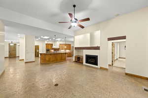 Unfurnished living room featuring a fireplace, ceiling fan, and recessed lighting