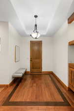 Entrance foyer with a tray ceiling and wood finished floors