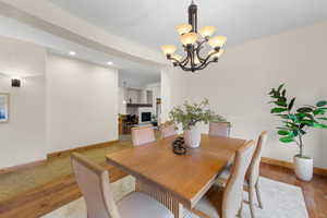 Dining area with wood finished floors and a chandelier