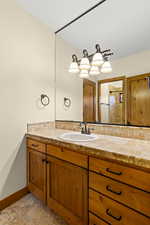 Bathroom with vanity, a tile shower, and light tile patterned floors