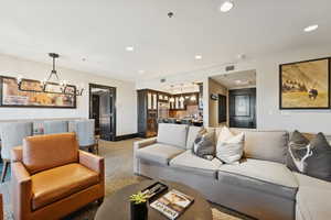 Living room featuring recessed lighting, a chandelier, and carpet floors