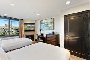 Bedroom featuring recessed lighting and a glass covered fireplace