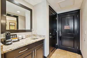 Bathroom featuring vanity, light tile patterned flooring, and recessed lighting