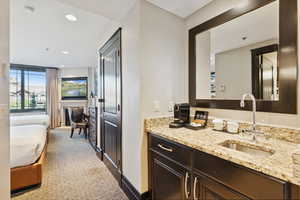Ensuite bathroom with vanity, dark carpet, and recessed lighting