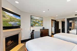 Bedroom featuring recessed lighting, a fireplace, and light aggregate flooring