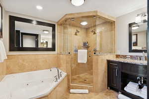 Bathroom with vanity, a jetted tub, a stall shower, tile walls, and light tile patterned floors