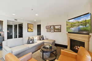 Living area with recessed lighting and a glass covered fireplace
