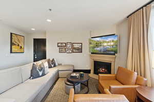 Living room featuring a fireplace with flush hearth and recessed lighting