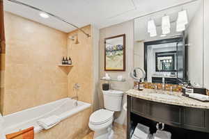 Bathroom with tiled shower / bath combo, recessed lighting, vanity, and tile patterned floors