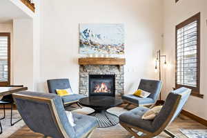 Living area with a stone fireplace and wood finished floors