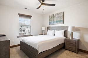 Carpeted bedroom featuring baseboards and a ceiling fan