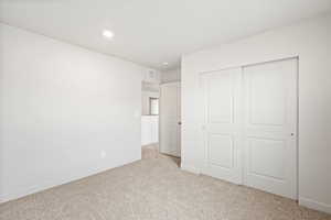 Unfurnished bedroom with carpet floors, a closet, and recessed lighting