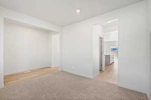 Unfurnished room featuring light colored carpet, recessed lighting, and light wood-style flooring