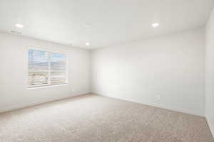 Carpeted spare room featuring baseboards and recessed lighting