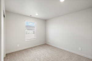 Empty room featuring light colored carpet and recessed lighting