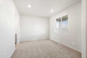 Unfurnished room with light colored carpet and recessed lighting