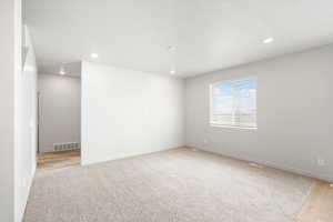 Empty room featuring recessed lighting and light colored carpet