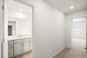 Bathroom with vanity, light carpet, and recessed lighting