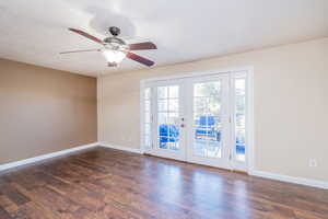 Spare room featuring french doors, a textured ceiling, dark wood finished floors, and a ceiling fan