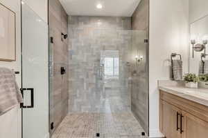 Full bath featuring vanity, a shower stall, and recessed lighting