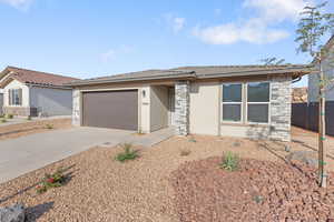 View of front of house with stucco siding, concrete driveway, stone siding, a garage, and a tile roof