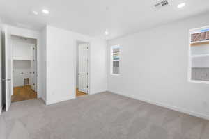 Unfurnished bedroom featuring light carpet and recessed lighting