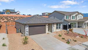 Traditional-style home featuring concrete driveway, stucco siding, stone siding, and an attached garage