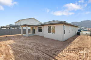 Rear view of house with a patio area, a tiled roof, and stucco siding