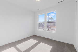 Carpeted empty room featuring baseboards