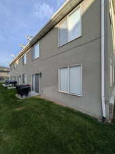Rear view of house with a yard, stucco siding, and a patio