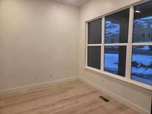 Office with light wood finished floors and recessed lighting