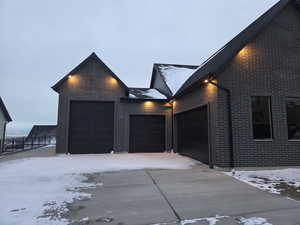View of front facade featuring brick siding, concrete driveway, and a garage