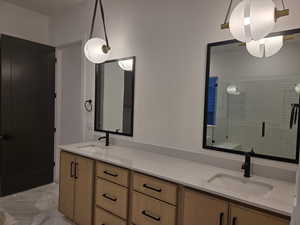 Full bath featuring double vanity and a shower stall