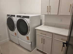 Laundry area featuring independent washer and dryer and cabinet space