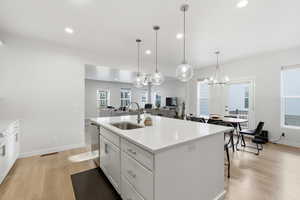 Kitchen with stainless steel appliances, quartz oversized island, pendant lights and open floorplan.