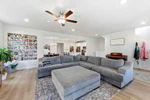 Living area featuring recessed lighting, light wood-type flooring, a ceiling fan, and a chandelier