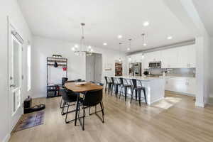 Dining space with recessed lighting, light wood finished floors, and a chandelier