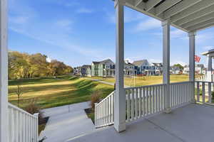 Covered porch with a view of adjacent grassy common areas