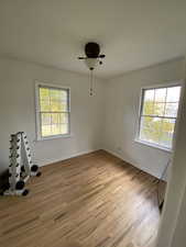 Unfurnished room featuring healthy amount of natural light, light wood-type flooring, and a ceiling fan